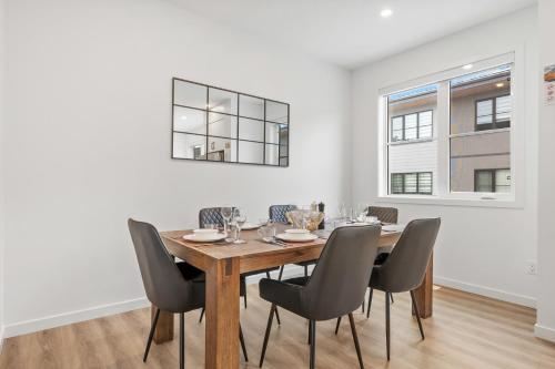 a dining room with a wooden table and chairs at Luxury 3 Bedrooms Spacious Townhome, 2 Car Garage, Sleeps 8, Heater & AC, King Bed, Easy Ski Access, Next to WinSport, 10km from Calgary Downtown, Near Banff in Calgary