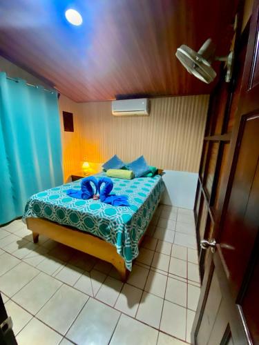 a bedroom with a bed with a blue comforter at Cabaña que Tuanis in Fortuna