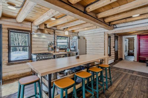 a kitchen with a large wooden table and stools at Log Cabin Fireplace Upper Valley - Wooded Chalet in Hartland