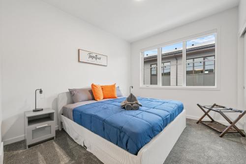 a bedroom with a bed with blue sheets and a window at Luxury 3 Bedrooms Spacious Townhome, 2 Car Garage, Sleeps 8, Heater & AC, King Bed, Easy Ski Access, Next to WinSport, 10km from Calgary Downtown, Near Banff in Calgary