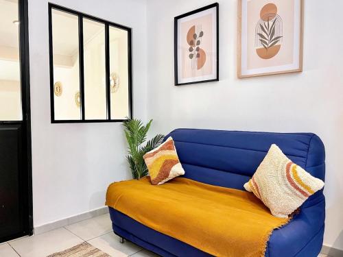 - un canapé bleu avec des oreillers dans l'établissement Lou Cantou - Centre historique, Cosy, Wifi, 4 personnes, à Istres