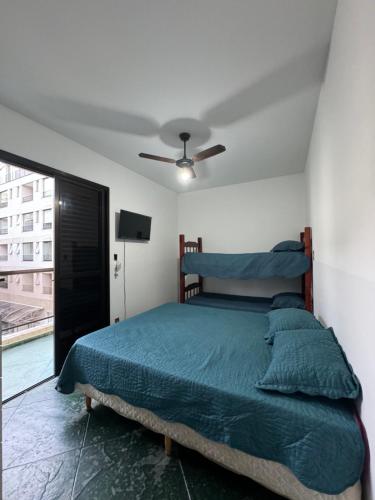 a bedroom with a bed and a ceiling fan at Ap 3 quartos praia grande vista pro mar área nobre in Ubatuba