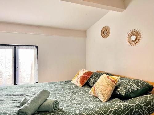 une chambre avec un lit avec des oreillers et une fenêtre dans l'établissement Lou Cantou - Centre historique, Cosy, Wifi, 4 personnes, à Istres