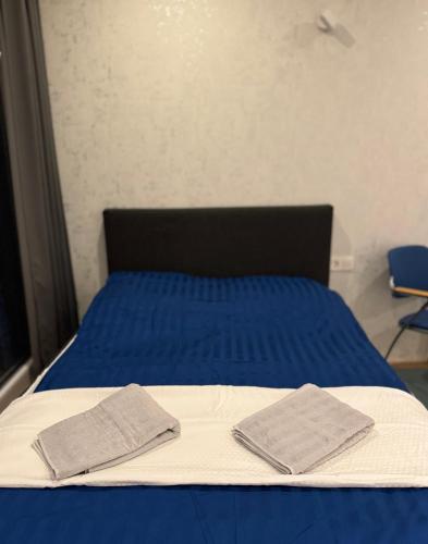 a bed with blue sheets and two towels on it at ESER Luxury Apartments in Bad Bellingen