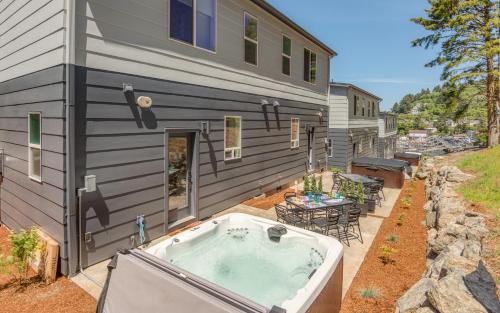 a hot tub on a patio next to a house at Harbor Lights 5 - Harbor Hideaway Quiet Charm in Depoe Bay