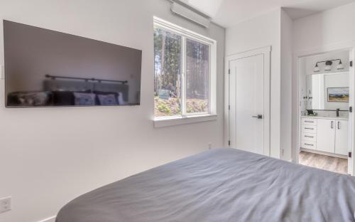 a white bedroom with a bed and a window at Harbor Lights 5 - Harbor Hideaway Quiet Charm in Depoe Bay