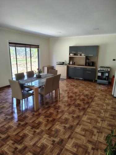 a dining room and kitchen with a table and chairs at Cabañas mi refugio salto del laja in Salto del Laja