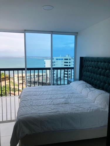 a bedroom with a bed and a view of the ocean at Punta Centinela in Punta Blanca
