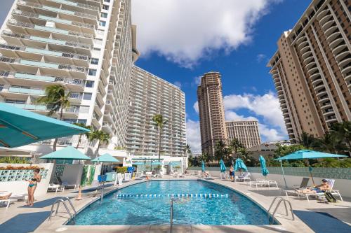 a pool in the middle of a city with tall buildings at Breathtaking Studio Ocean Views! Pool! Beach! in Honolulu
