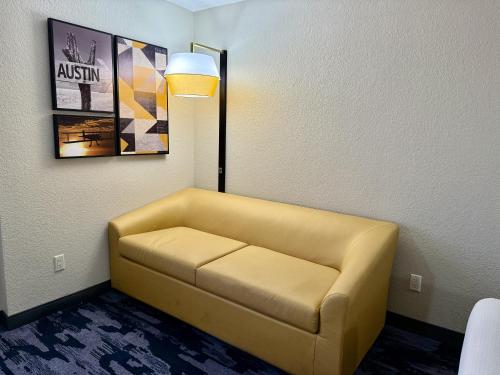 a yellow couch in a room with a lamp at La Quinta by Wyndham Austin Southwest in Austin