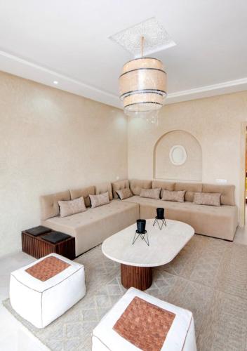 a living room with a couch and a table at VILLA NOÛR PALACE avec piscine jaccuzi à Marrakech in Marrakech
