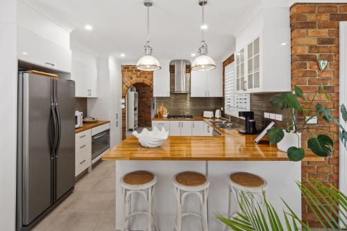 a kitchen with white cabinets and stainless steel appliances at Scotts Retreat- Relax by the Pool in Scotts Head