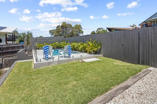 a yard with two blue chairs and a fence at Scotts Retreat- Relax by the Pool in Scotts Head