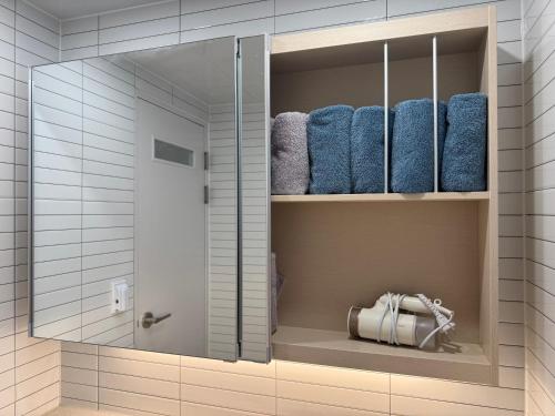 a bathroom with a shower with blue towels at Pachira House in Seoul