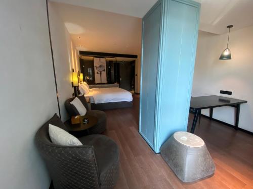 a room with a bedroom with a bed and a table at 柏高酒店-深圳公明广场地铁站店 in Bao'an