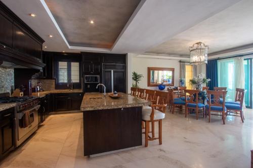 a kitchen with wooden cabinets and a dining room at Hacienda De Mita, Close to Ocean and Golf in Punta Mita