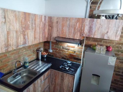 a small kitchen with a sink and a refrigerator at Apartamento Ibagué centro económico in Vallecito