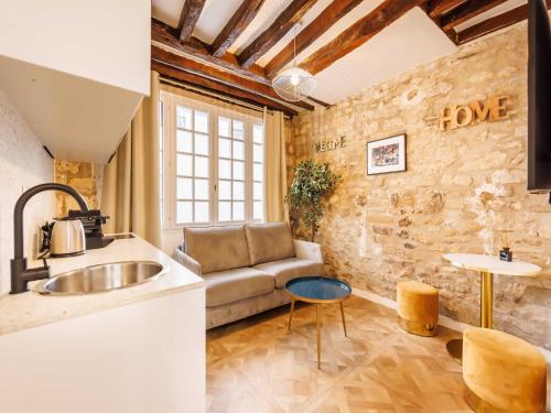 - une cuisine avec un canapé et un évier dans la chambre dans l'établissement Chic, comfortable flat near rue Montmartre, à Paris