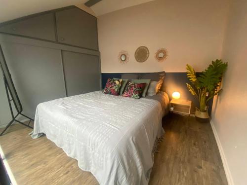 a bedroom with a white bed and a plant at Stylish & Cosy Mezzanine in Historical Old Town in Annecy