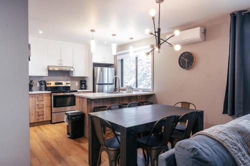 a kitchen with a table and chairs in a room at Mont Blanc Hôtel & Condos in Mont-Blanc