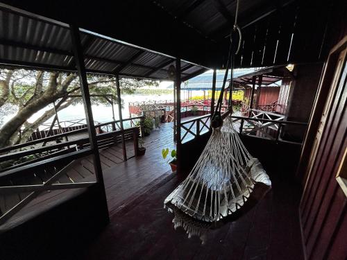 a hammock hanging from the side of a building at Vista do Lago Jungle Lodge in Cajual