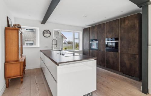 a kitchen with white walls and wooden cabinets at Haus Hilda in Grömitz
