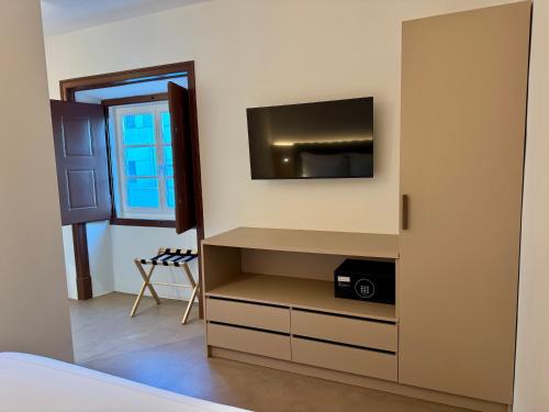 a room with a tv on a wall at CICIOSO boutique hotel in Évora