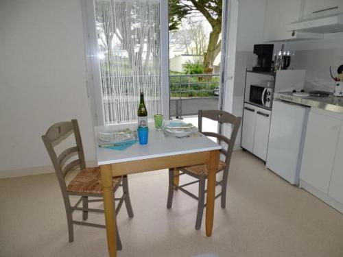 - une cuisine avec une table, des chaises et une bouteille de vin dans l'établissement Studio in Audierne near Finistère Beach, à Audierne