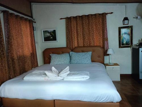 a bedroom with a large bed with a flower on it at Sukanya Garden and Home in Ban Lat Ya