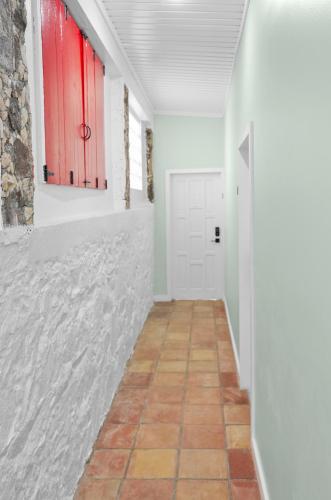 a hallway with a red door and a tile floor at The Mary Anne Boutique Hotel USVI in Charlotte Amalie