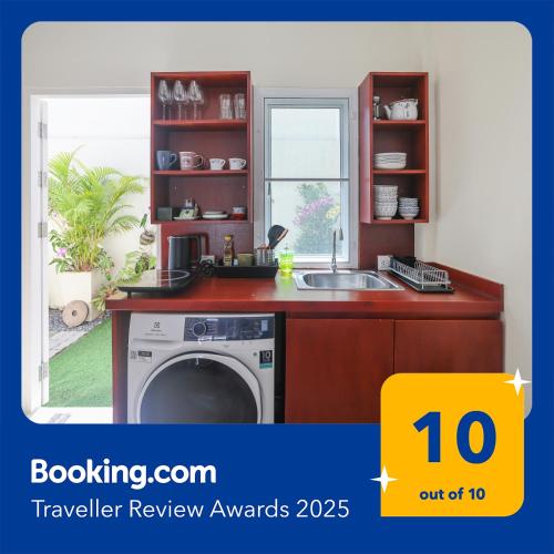 a kitchen with a washing machine and a sink at Spacious Family Garden Villa - Huge Pool & Gym Access in Thalang