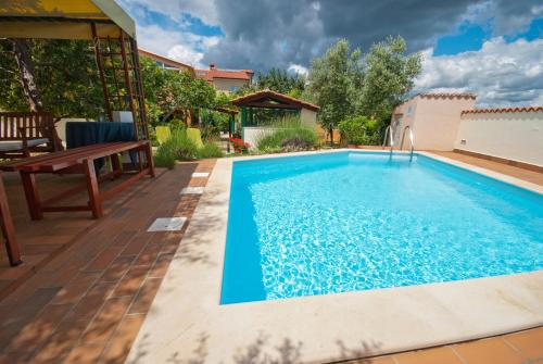 - une piscine dans un jardin avec un banc et une maison dans l'établissement Guest house Bizjak, à Vinkuran
