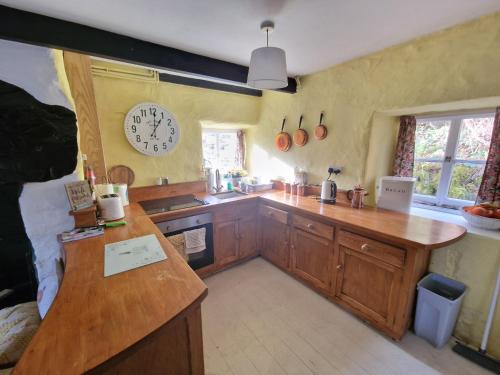 a kitchen with a counter and a clock on the wall at Quarry Cottage in Blaenau-Ffestiniog