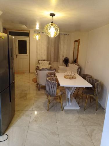 une cuisine et une salle à manger avec une table et des chaises dans l'établissement Résidence les jardins secrets, à Romilly-sur-Seine