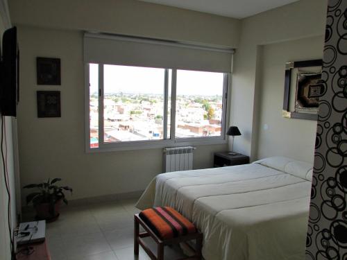 a bedroom with a bed and a large window at Tu Lugar en Salta in Salta