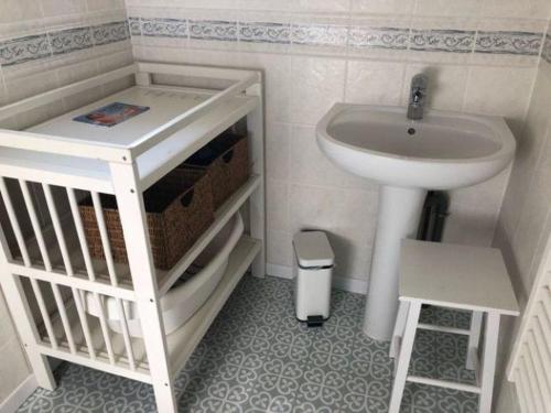 een kleine badkamer met een wastafel en een witte wastafel bij Gîte confortable près du Zoo de Beauval, avec jardin - FR-1-491-428 in Meusnes