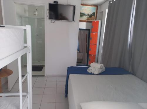 a bedroom with a bed and a tv on a wall at Pousada Rota do Sol in Cabo Frio