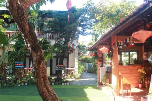 a building with a tree in front of it at Loc Phat Hoi An Homestay in Hoi An