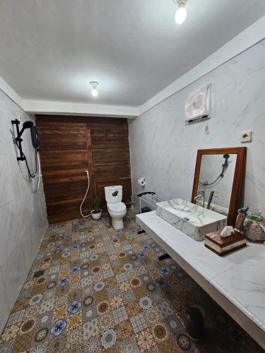 a bathroom with a toilet and a sink and a mirror at Amore Komodo in Labuan Bajo