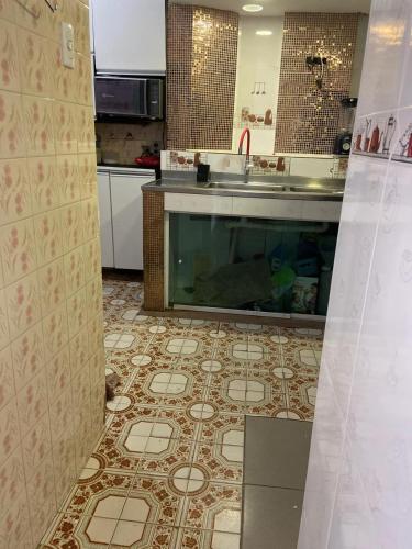a kitchen with a sink and a tile floor at Apartamento para o Carnaval in Recife
