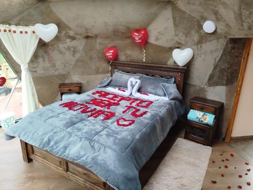 a bedroom with a bed with red writing on it at glamping casa blanca in Guatavita