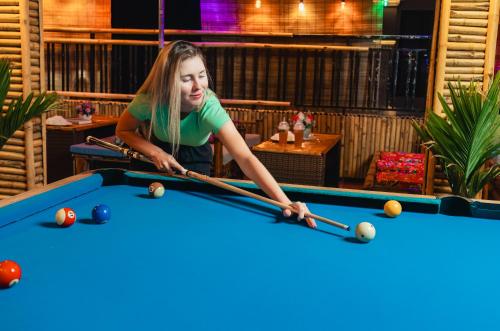 a young girl playing pool in a bar at Mountain Pearl Hotel in Cat Ba