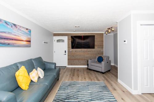 a living room with a blue couch and a tv at NEW! Remodeled & Upgraded Vacation Apartment in Sandusky