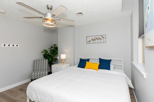 a bedroom with a white bed and a ceiling fan at NEW! Remodeled & Upgraded Vacation Apartment in Sandusky