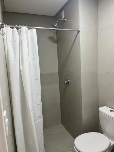 a bathroom with a shower curtain and a toilet at Apartamento alto padrão in Xangri-lá
