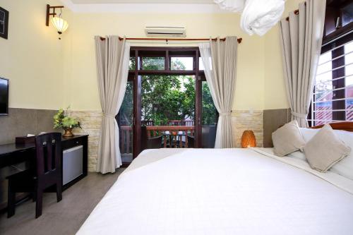 a bedroom with a large white bed and a window at Loc Phat Hoi An Homestay in Hoi An