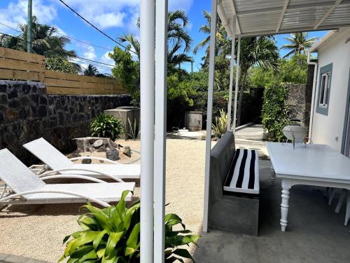 a group of white chairs and a table on a patio at Malena Guest House in Grand Baie
