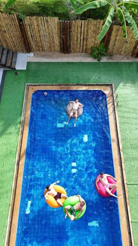 two people in a swimming pool with floats in it at Hangover Chill & Hill Hostel in Phi Phi Don