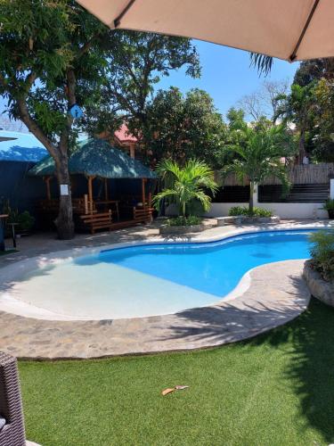 una piscina in un cortile con ombrellone di The Barkly House Staycation a Biñan