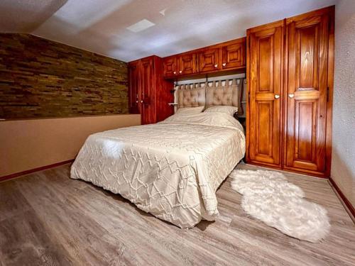 - une chambre avec un lit et des placards en bois dans l'établissement Duplex tout confort pour 4 pers. proche pistes, avec balcon et parking - FR-1-733-163, à Crest-Voland